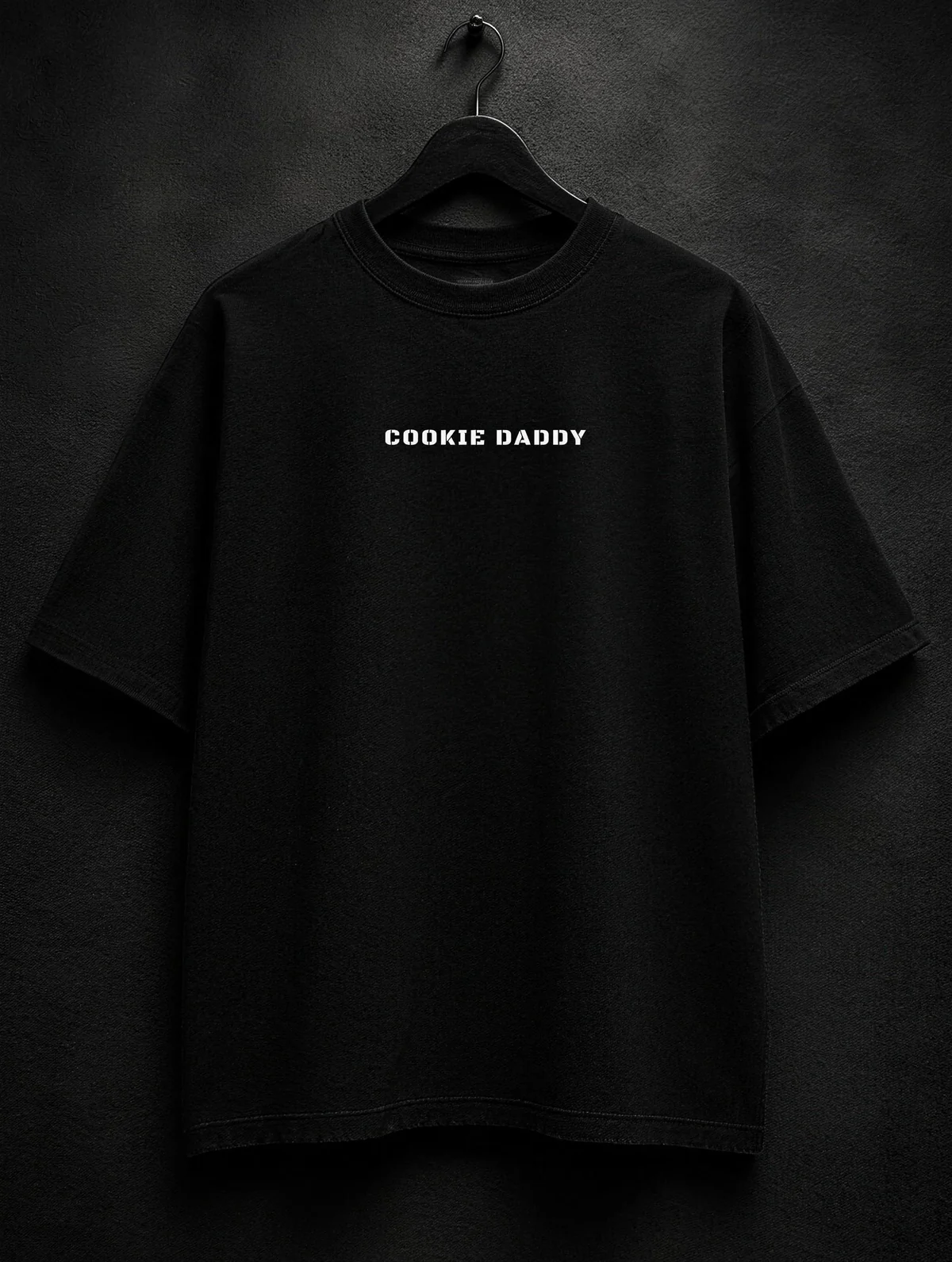 Black tee, COOKIE DADDY in white letters across the chest